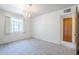 Vacant carpeted bedroom with a window and door at 1945 E Solano Dr, Phoenix, AZ 85016