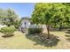 The side yard of the home features landscaping, trees, and manicured lawn with an orange tree at 1945 E Solano Dr, Phoenix, AZ 85016