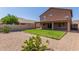 View of the backyard featuring lush green grass, desert landscaping, and a covered patio at 19933 N Emmerson Dr, Maricopa, AZ 85138