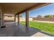Covered patio overlooks a well-maintained backyard featuring green grass, privacy walls and desert landscaping at 19933 N Emmerson Dr, Maricopa, AZ 85138