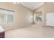 Bright living room with neutral carpet, vaulted ceilings, and large windows at 19933 N Emmerson Dr, Maricopa, AZ 85138