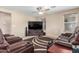 Inviting living room featuring comfortable seating, a ceiling fan, and large TV at 19933 N Emmerson Dr, Maricopa, AZ 85138