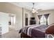 Comfortable main bedroom featuring neutral colors, a ceiling fan, and natural light at 19933 N Emmerson Dr, Maricopa, AZ 85138