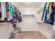 Walk-in closet provides ample storage with shelving on all sides and carpet flooring at 19933 N Emmerson Dr, Maricopa, AZ 85138