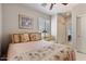 Cozy bedroom featuring soft floral bedding, plantation shutters, and an ensuite bathroom at 21109 W Sunrise Ln, Buckeye, AZ 85396