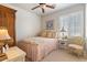 Charming bedroom with a floral-patterned bedspread, ceiling fan, and window with shutter, creating a cozy ambiance at 21109 W Sunrise Ln, Buckeye, AZ 85396
