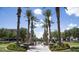 Beautifully landscaped community featuring a water fountain, lush trees, and palm-lined streets at 21109 W Sunrise Ln, Buckeye, AZ 85396