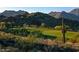 Picturesque view of a golf course with lush green fairways and desert landscaping, set against a mountain backdrop at 21109 W Sunrise Ln, Buckeye, AZ 85396