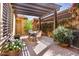 Charming outdoor patio with a pergola, blooming bougainvillea, and a dining table set for entertaining at 21109 W Sunrise Ln, Buckeye, AZ 85396