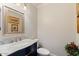Stylish powder room featuring a blue vanity, marble countertop, and decorative gold framed artwork at 21109 W Sunrise Ln, Buckeye, AZ 85396