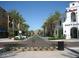 Street-level view of a landscaped street lined with buildings, palm trees, and mountain views in the distance at 21109 W Sunrise Ln, Buckeye, AZ 85396