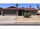 Charming single-story home featuring desert landscaping, a two-car garage, and a welcoming arched entryway at 2130 W Devonshire St, Mesa, AZ 85201