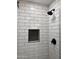 Shower showcases white subway tile, black fixtures, and a niche for storage at 2130 W Devonshire St, Mesa, AZ 85201