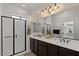 This bright bathroom features a glass-door shower, dark cabinets, double sinks, and a large mirror at 2145 N 88Th St, Mesa, AZ 85207