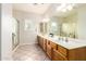 Bright bathroom features tile flooring, a large mirror, and a double vanity at 22626 W Gibson Ln, Buckeye, AZ 85326