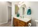 Comfortable bathroom featuring a wooden vanity, and a round mirror, complemented by great lighting at 22626 W Gibson Ln, Buckeye, AZ 85326