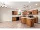 Kitchen with wood cabinets, tile flooring, and an island at 22626 W Gibson Ln, Buckeye, AZ 85326