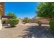 This backyard has low-maintenance desert landscaping, a brick firepit area, mature trees, and a covered patio at 2329 E Ebony Dr, Chandler, AZ 85286