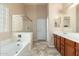 Bathroom with a bathtub, glass-enclosed shower, and vanity with dark wood cabinetry at 2329 E Ebony Dr, Chandler, AZ 85286