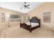 Main bedroom with a ceiling fan, large windows, and a decorative headboard at 2329 E Ebony Dr, Chandler, AZ 85286