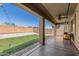 Covered back patio features tile flooring and overlooks the well-maintained backyard with synthetic grass and white gravel at 23848 W Grove St, Buckeye, AZ 85326