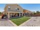 A spacious backyard featuring synthetic grass, a covered patio, and a trampoline at 23848 W Grove St, Buckeye, AZ 85326