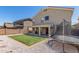A beautiful backyard featuring synthetic grass, a covered patio, and a trampoline at 23848 W Grove St, Buckeye, AZ 85326