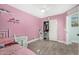 Pink bedroom with tiled floors, ceiling fan and closet offers a cozy and functional living space at 23848 W Grove St, Buckeye, AZ 85326