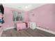 Pink bedroom featuring a ceiling fan, tiled floor and window with privacy curtains for a comforting space at 23848 W Grove St, Buckeye, AZ 85326