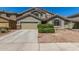 Charming home with a two-car garage, well-maintained landscaping, and desert-style rock ground cover at 23848 W Grove St, Buckeye, AZ 85326