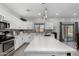 Modern kitchen with center island, stainless appliances, pendant lights, and white cabinets at 23848 W Grove St, Buckeye, AZ 85326
