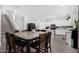 Eat-in kitchen features marble table with seating for eight, stainless appliances, and white cabinetry at 23848 W Grove St, Buckeye, AZ 85326