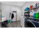 Functional laundry room with modern washer/dryer, gray tile flooring, and ample storage solutions at 23848 W Grove St, Buckeye, AZ 85326