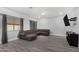 Spacious living room features wood-look tile, recessed lighting, and a large sectional sofa for comfortable seating at 23848 W Grove St, Buckeye, AZ 85326