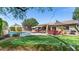 Expansive backyard featuring a pool, putting green, covered patio, and lush landscaping at 2585 E Morgan Dr, Gilbert, AZ 85295