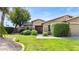 Charming home with well-maintained landscaping, including shrubs and a large shade tree at 2585 E Morgan Dr, Gilbert, AZ 85295