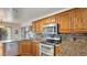 Modern kitchen with granite countertops, stainless steel appliances, and wooden cabinetry at 2585 E Morgan Dr, Gilbert, AZ 85295