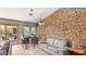 Bright room with brick accent wall, light gray sofa, and open view to the backyard at 2585 E Morgan Dr, Gilbert, AZ 85295