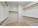 Spacious walk-in closet with wooden rods and shelving, offering ample storage and organization solutions at 25925 N 53Rd Dr, Phoenix, AZ 85083