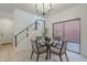 Dining area features a glass table, chandelier, and staircase access at 25925 N 53Rd Dr, Phoenix, AZ 85083