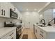 Contemporary kitchen featuring white cabinetry, sleek appliances, and open access to other rooms at 25925 N 53Rd Dr, Phoenix, AZ 85083