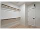 Bright walk-in closet with wood shelves, rod, and door at 25925 N 53Rd Dr, Phoenix, AZ 85083