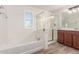 Bright bathroom featuring a soaking tub, glass shower, and wood-look floors at 28967 N 124Th Ave, Peoria, AZ 85383