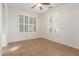 Bright bedroom with white walls, tiled floor, ceiling fan and plantation shutters on the two windows at 28967 N 124Th Ave, Peoria, AZ 85383