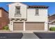 A two-story home has two garage doors and neutral stucco exterior with a tile roof at 28967 N 124Th Ave, Peoria, AZ 85383