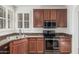 Kitchen with wood cabinets, granite countertops, stainless sink, and black appliances at 28967 N 124Th Ave, Peoria, AZ 85383