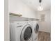 A laundry room is equipped with modern appliances, a pendant light, and ample shelving for organized storage at 28967 N 124Th Ave, Peoria, AZ 85383