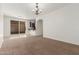 Open living room with carpeted floor, sliding doors, and bar seating to kitchen at 28967 N 124Th Ave, Peoria, AZ 85383