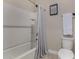 Clean bathroom featuring a tiled shower-tub, tiled floors, modern hardware, and essential fixtures at 296 N Jesse St, Chandler, AZ 85225