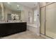 Bright bathroom boasts double sinks, dark cabinets, modern fixtures, tub, and a separate glass shower at 296 N Jesse St, Chandler, AZ 85225